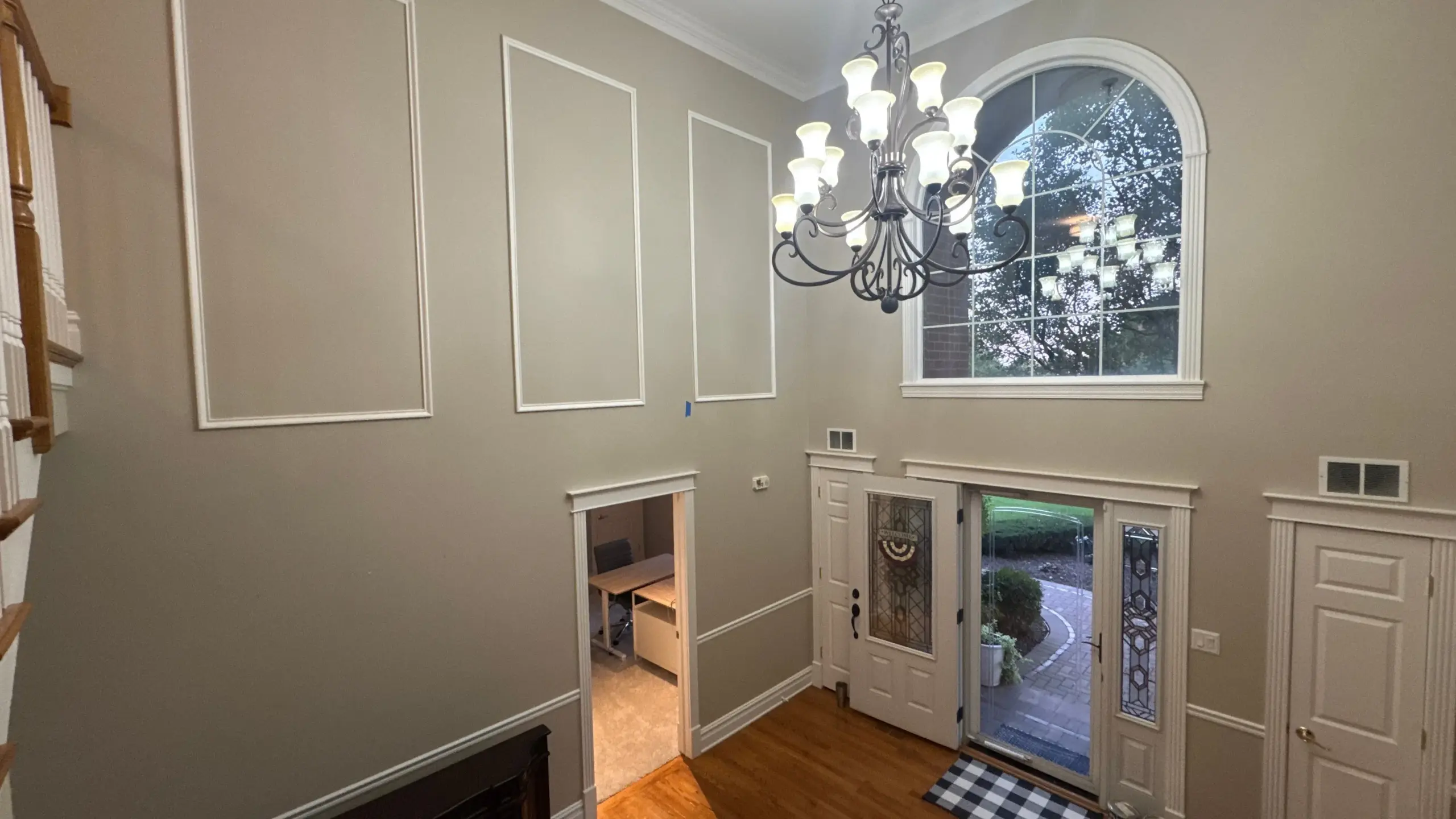 Foyer with painted crown molding, trim, and architectural details